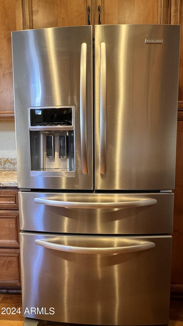 interior details featuring stainless steel fridge and light stone countertops