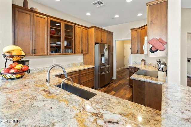 kitchen featuring stainless steel fridge with ice dispenser, sink, light stone countertops, and dark hardwood / wood-style floors