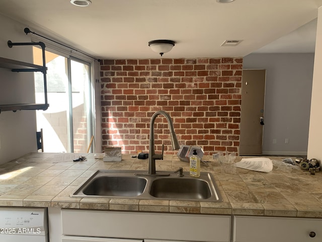 kitchen featuring white cabinetry, white dishwasher, and sink