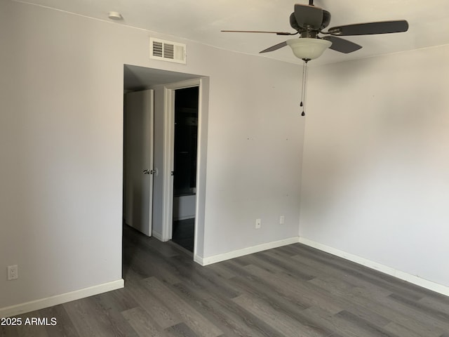 empty room with ceiling fan and dark hardwood / wood-style flooring