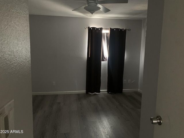 spare room featuring dark wood-type flooring and ceiling fan