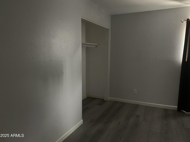 unfurnished bedroom featuring dark wood-type flooring and a closet