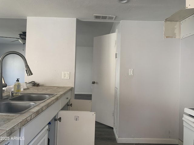 kitchen featuring sink, dark hardwood / wood-style floors, white cabinets, and ceiling fan