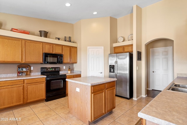 kitchen featuring light countertops, light tile patterned floors, a high ceiling, arched walkways, and black appliances