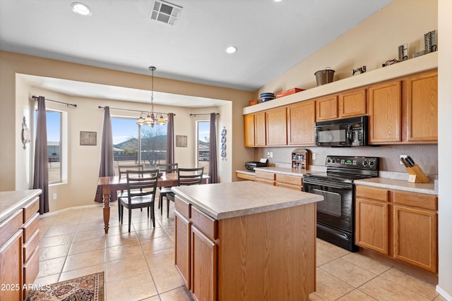 kitchen featuring light tile patterned floors, black appliances, a center island, and light countertops