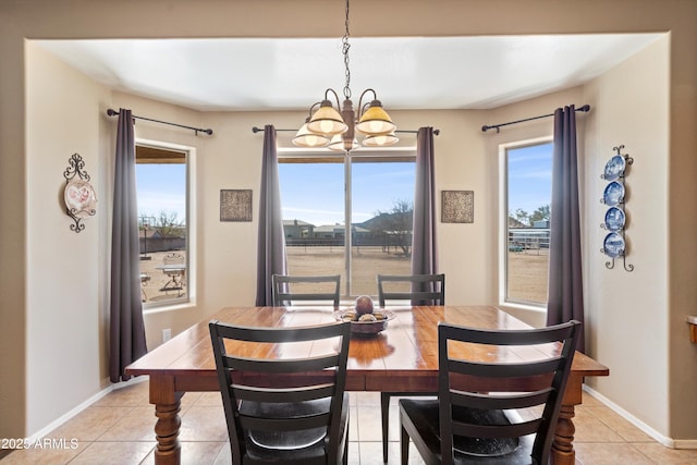 dining area featuring light tile patterned floors, baseboards, and a chandelier