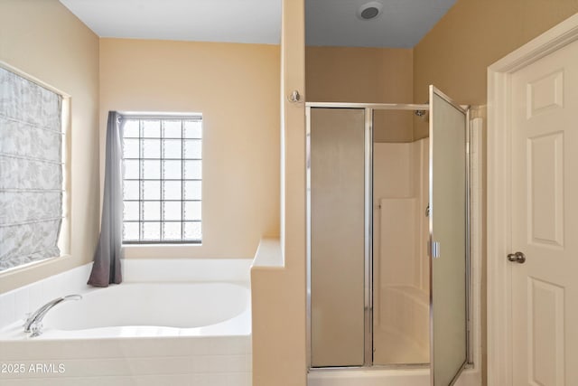 full bathroom featuring a garden tub and a stall shower