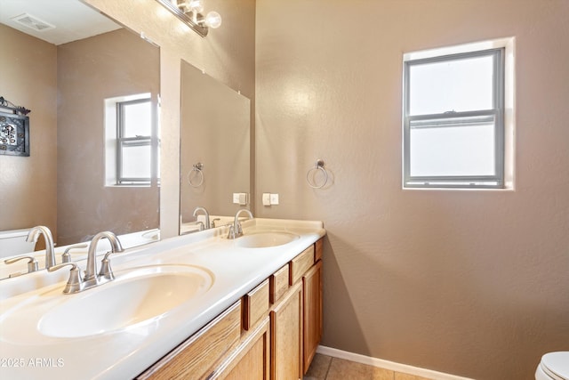 full bathroom with double vanity, visible vents, baseboards, and a sink