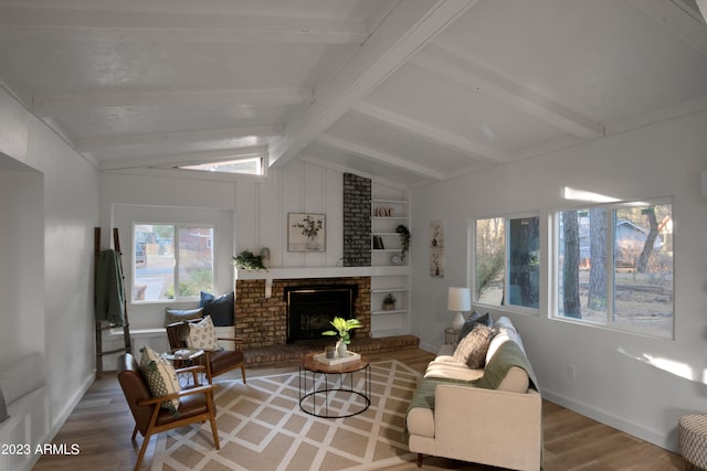 living room with brick wall, a brick fireplace, built in features, light wood-type flooring, and lofted ceiling with beams