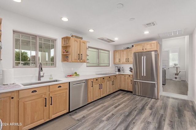 kitchen featuring appliances with stainless steel finishes, light brown cabinets, hardwood / wood-style flooring, and sink