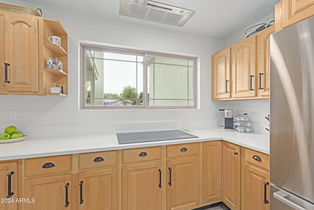 kitchen with stainless steel refrigerator, black electric stovetop, and light brown cabinets