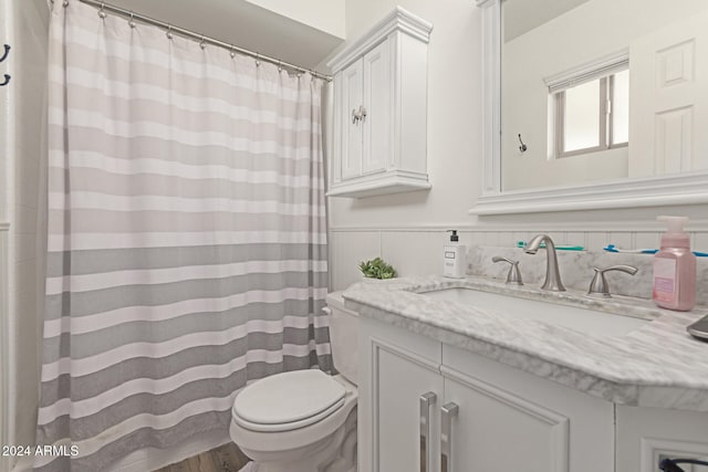 bathroom featuring vanity, wood-type flooring, and toilet