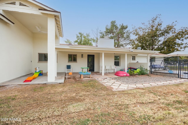 rear view of property featuring a patio area and a lawn