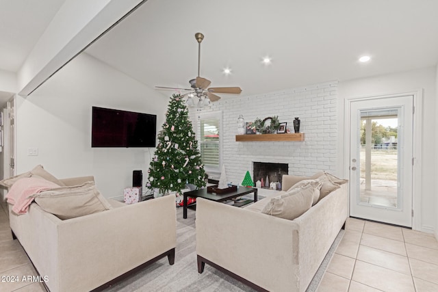 living room featuring a fireplace, ceiling fan, lofted ceiling, and light tile patterned flooring