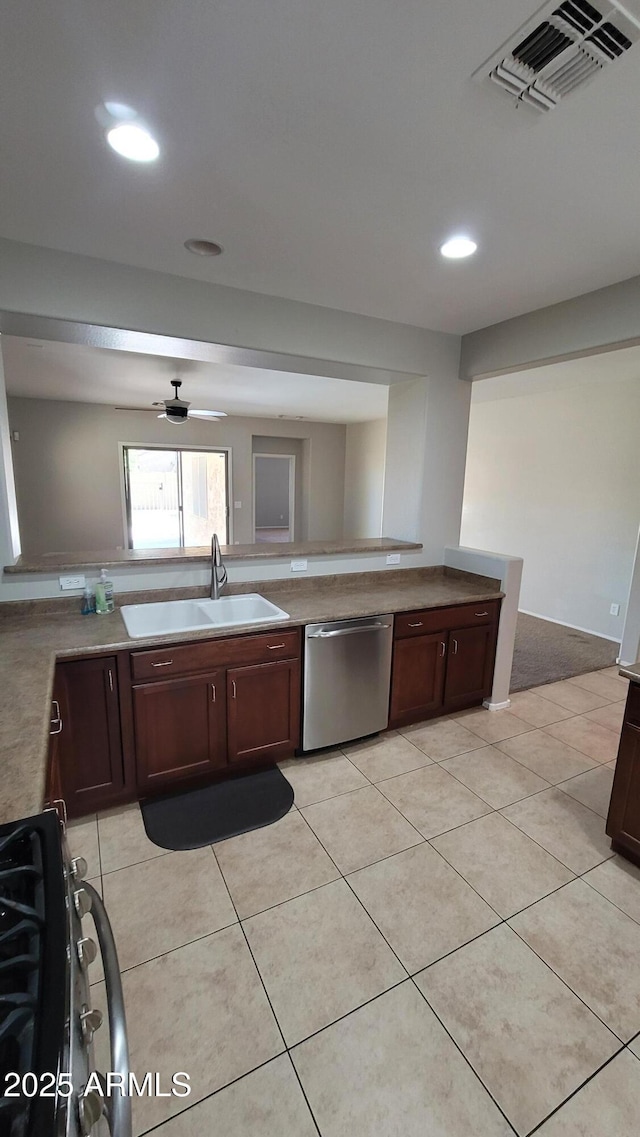 kitchen with dishwasher, a sink, range with gas stovetop, dark brown cabinets, and light tile patterned floors