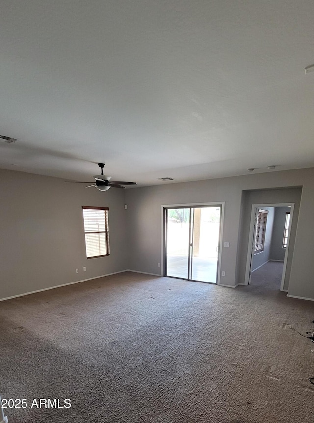 empty room with carpet, baseboards, and a ceiling fan