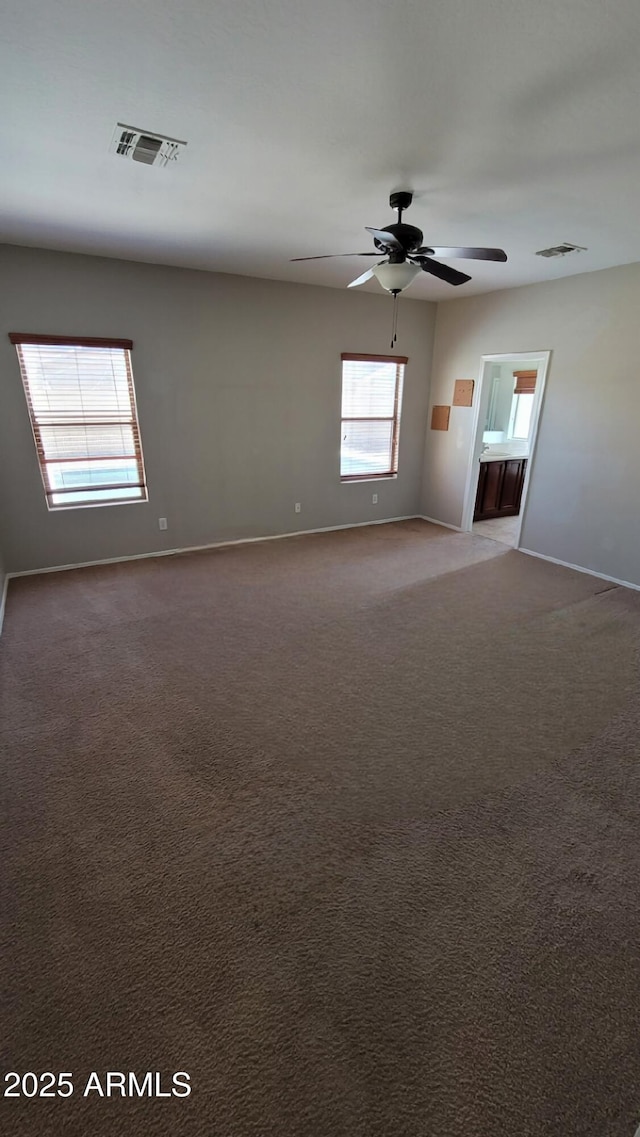 unfurnished room featuring baseboards, a ceiling fan, and carpet