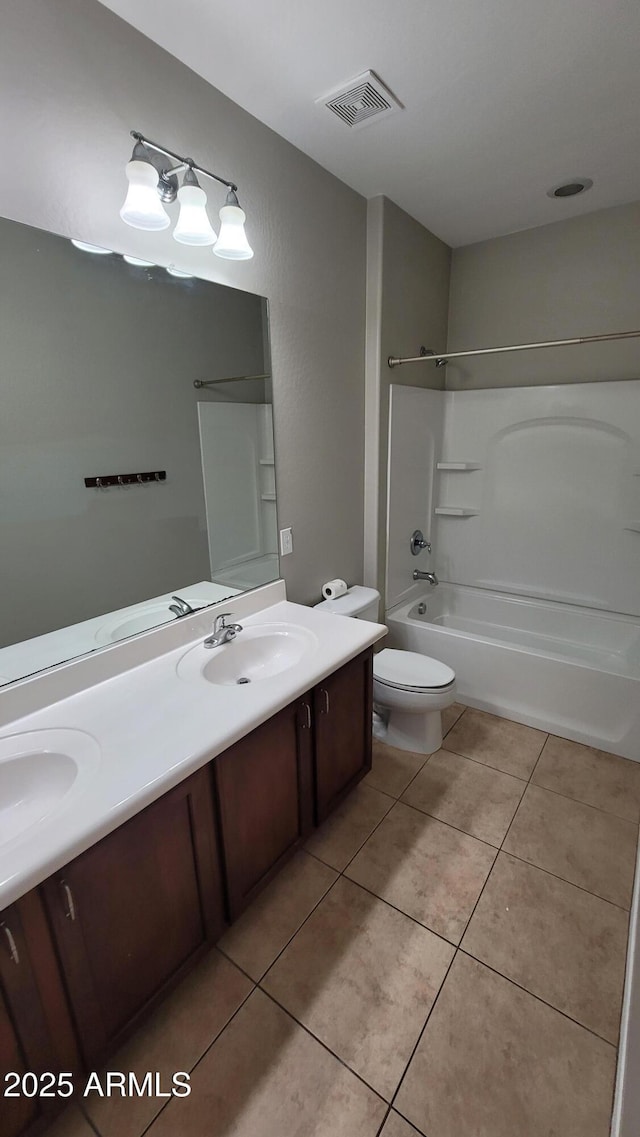 bathroom featuring tile patterned flooring, toilet, double vanity, and shower / bathtub combination