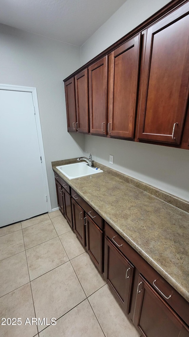 laundry room with a sink and light tile patterned floors