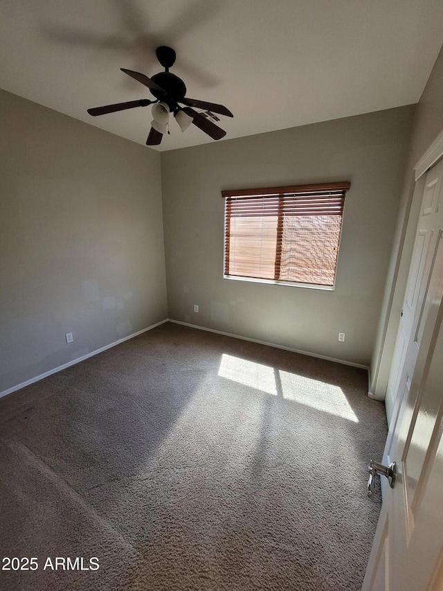 unfurnished bedroom with carpet flooring, baseboards, a ceiling fan, and a closet