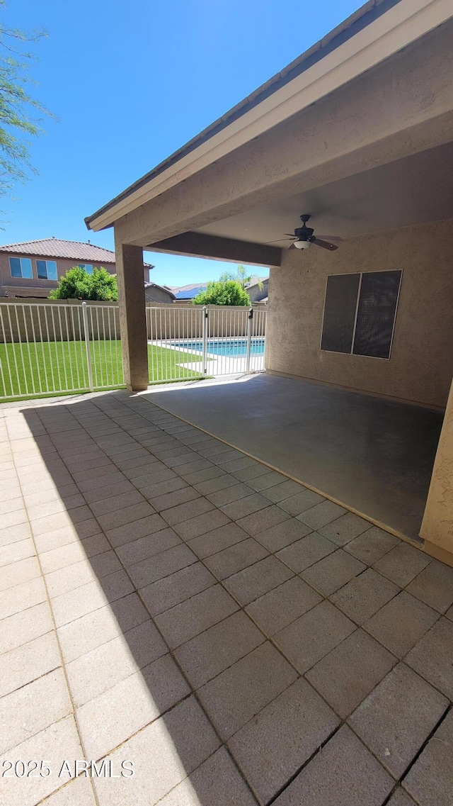 view of swimming pool featuring ceiling fan, fence, and a patio area