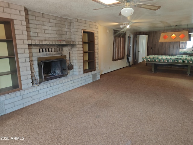 5463 E Roberts Dr, Globe, AZ 85501 - unfurnished living room featuring carpet flooring, a brick fireplace, ceiling fan, and wood walls
