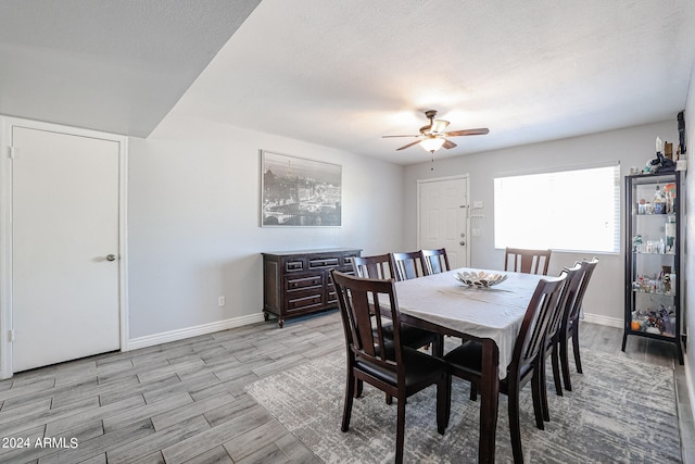 dining space with light hardwood / wood-style flooring, a textured ceiling, and ceiling fan