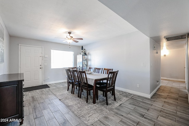 dining space with light hardwood / wood-style flooring, a textured ceiling, and ceiling fan