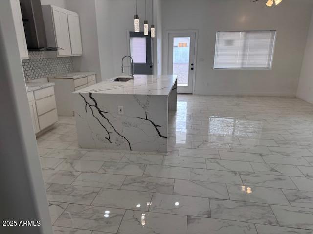 6633 N 54th Dr, Glendale, AZ 85301 - kitchen featuring light stone countertops, an island with sink, white cabinets, marble finish floor, and a sink