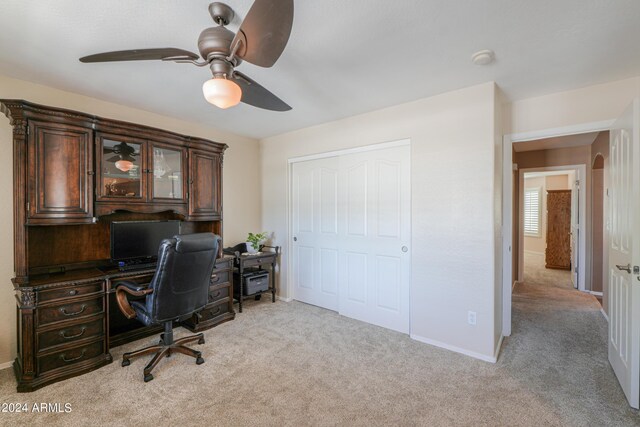 carpeted home office featuring ceiling fan