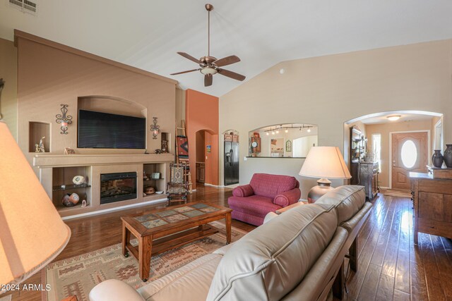 living room featuring dark hardwood / wood-style flooring, vaulted ceiling, and ceiling fan