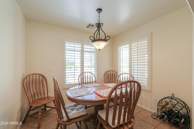 dining space featuring light tile patterned flooring, visible vents, and baseboards