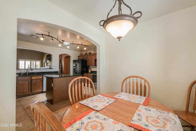 dining area featuring light tile patterned floors, visible vents, and arched walkways