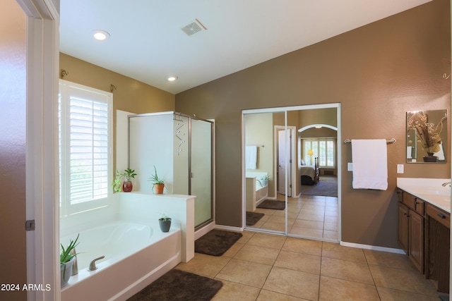 ensuite bathroom featuring ensuite bathroom, a garden tub, vanity, visible vents, and vaulted ceiling