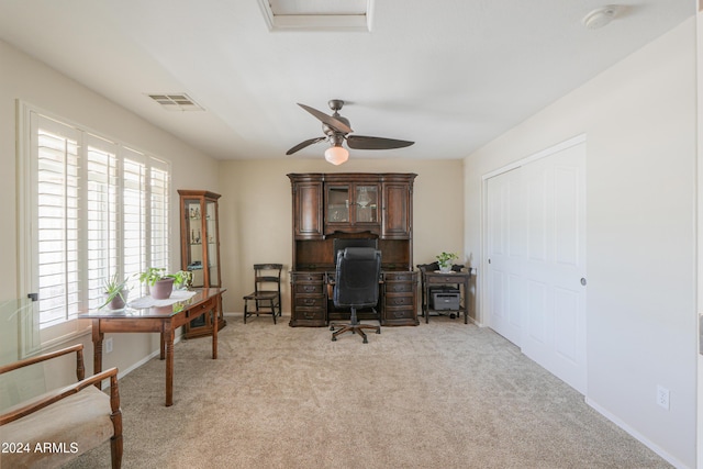 office featuring light colored carpet, visible vents, ceiling fan, and baseboards