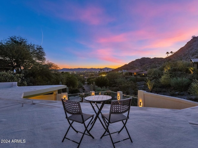 patio terrace at dusk featuring a mountain view