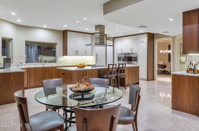 tiled dining room featuring a chandelier