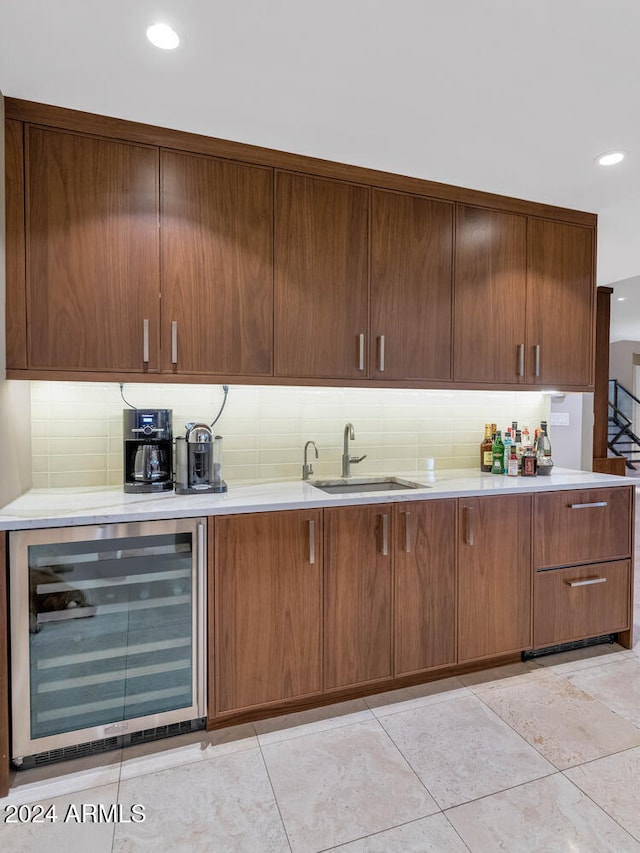 kitchen featuring wine cooler, sink, and tasteful backsplash