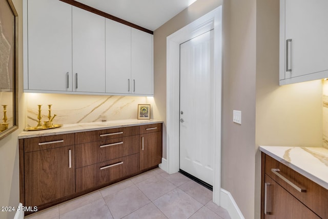 interior space featuring light tile patterned floors and white cabinets