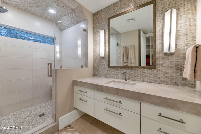 bathroom with an enclosed shower, vanity, and backsplash