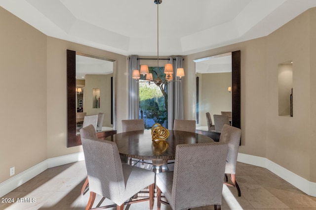 dining space featuring a chandelier and a raised ceiling