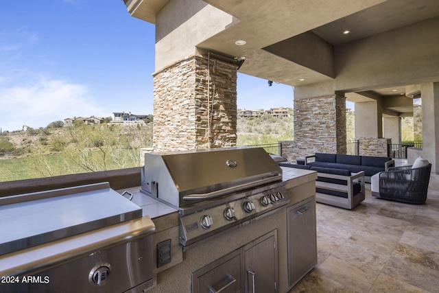 view of patio with grilling area, an outdoor living space, and exterior kitchen