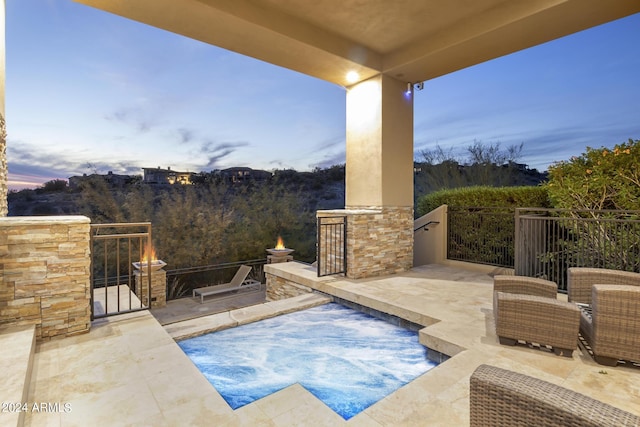 pool at dusk featuring an outdoor kitchen