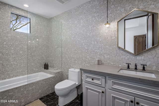 full bathroom with vanity, toilet, tile walls, and tiled shower / bath