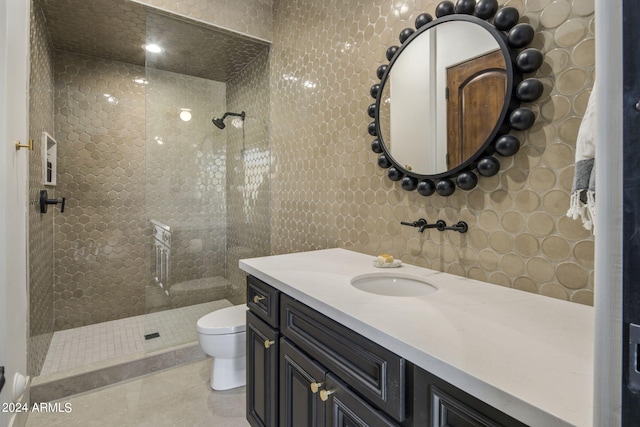 bathroom with tile patterned floors, vanity, toilet, and a shower