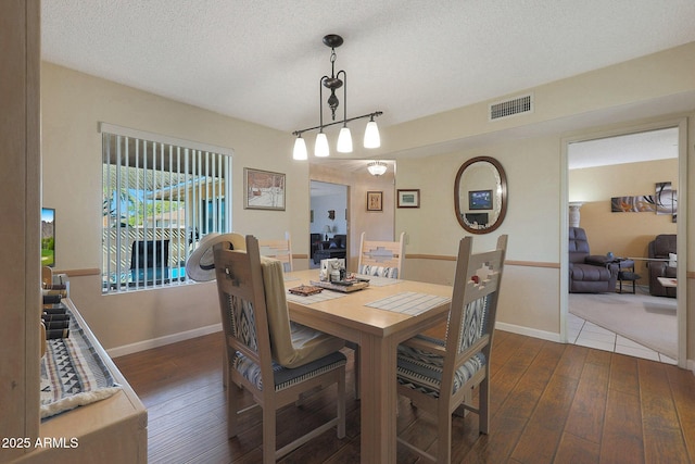 dining area featuring a textured ceiling and dark hardwood / wood-style flooring