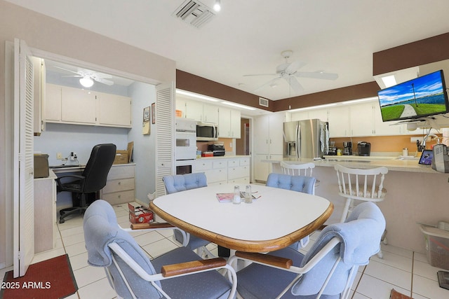 tiled dining space featuring ceiling fan and sink