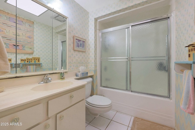 full bathroom with bath / shower combo with glass door, toilet, vanity, and tile patterned flooring