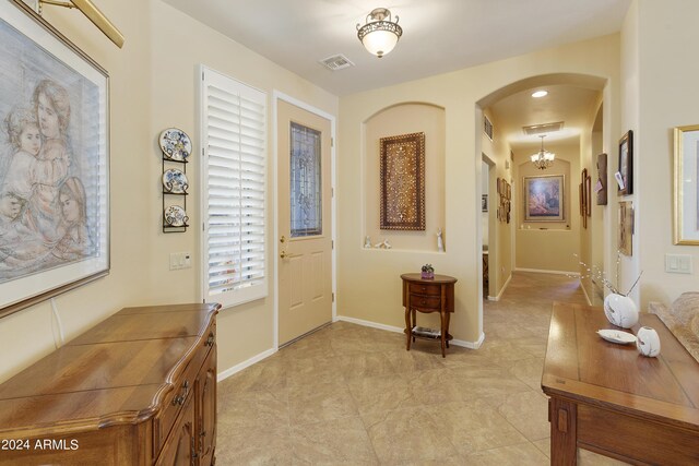 entryway with a chandelier