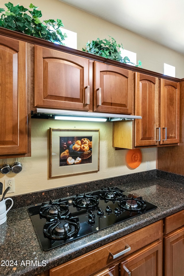 kitchen with dark stone counters and black gas stovetop